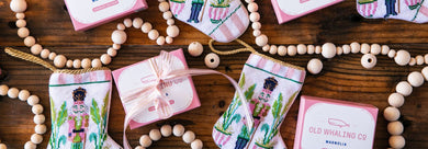 Pink boxed Magnolia soaps flatlay with Bauble Stockings and holiday wooden garland