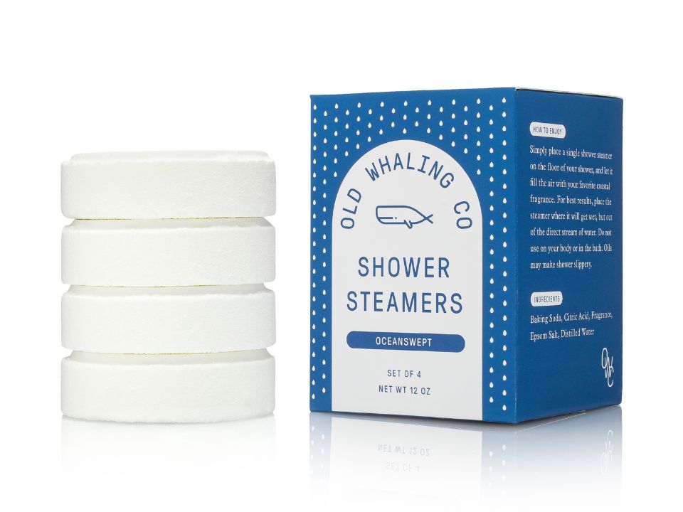 Set of four shower steamers with their packaging on a white background