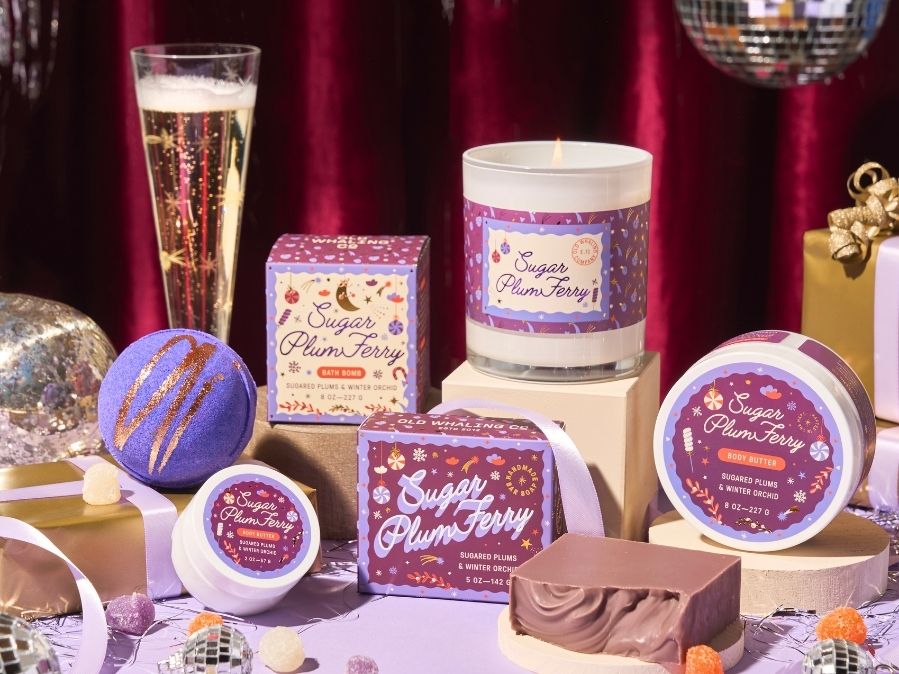 Collection of 'Sugar Plum Fairy' themed products including candles and bath bombs on a decorative background.