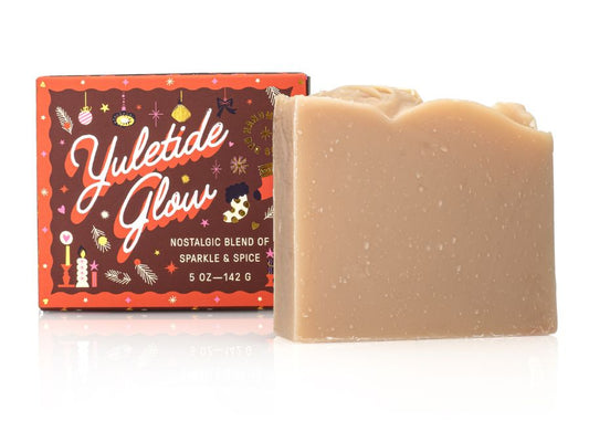 Bar of soap with a decorative Yuletide Glow packaging on a white background