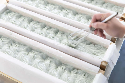 Production member creating soap waves on Coastal Calm bar soap