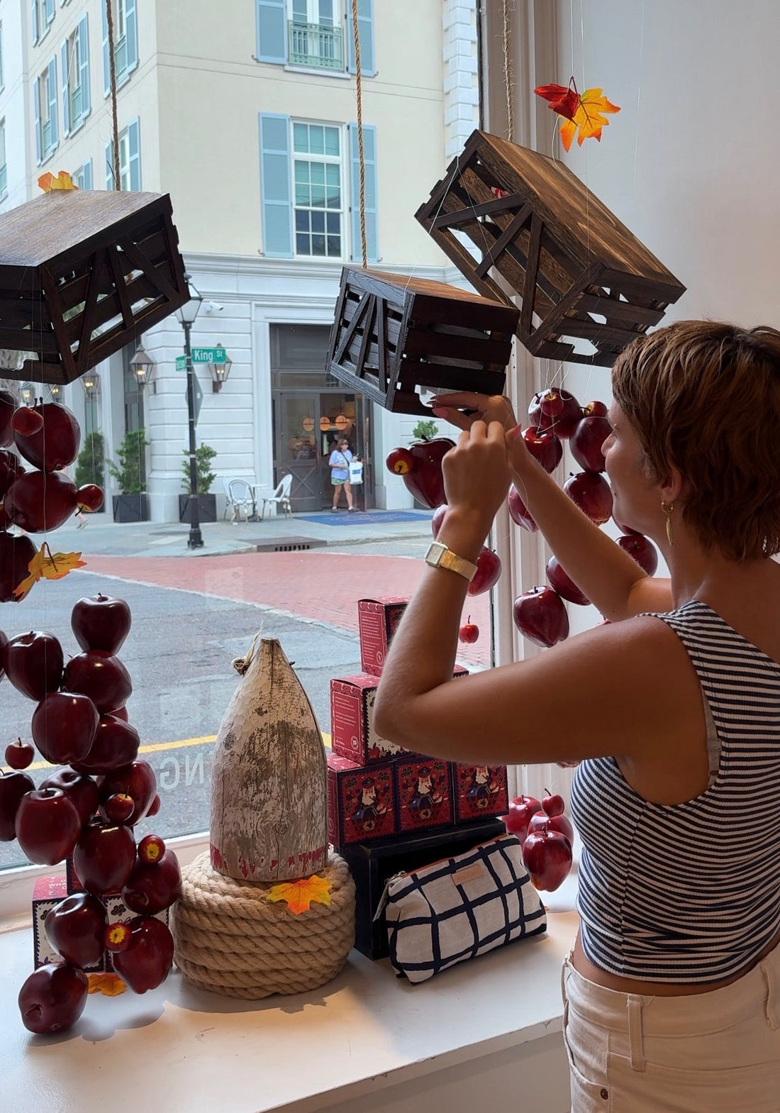 Megan hanging up apples in retail store windows