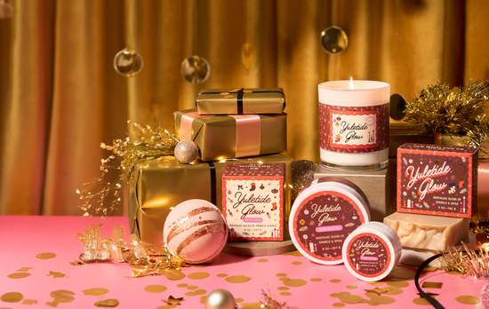Holiday-themed products including candles, gift boxes, and bath products on a festive tablecloth.