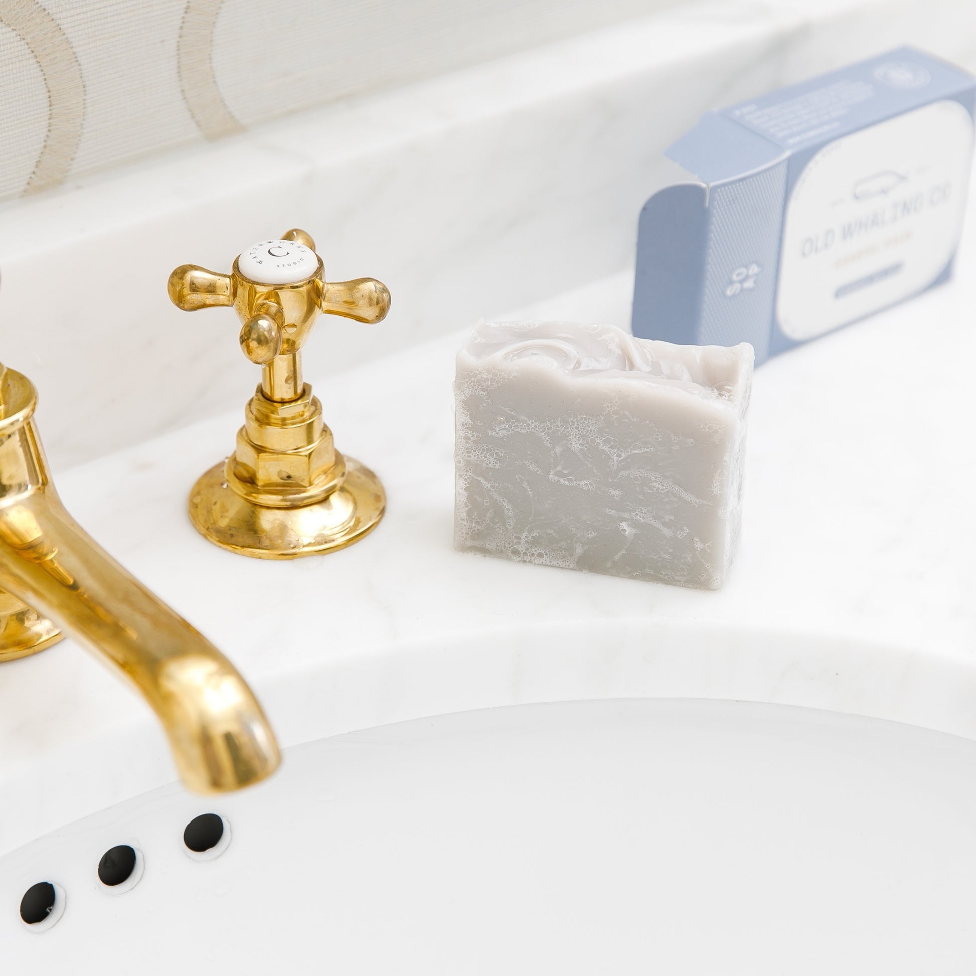 Coastal Calm Bar Soap with suds sitting beside sink