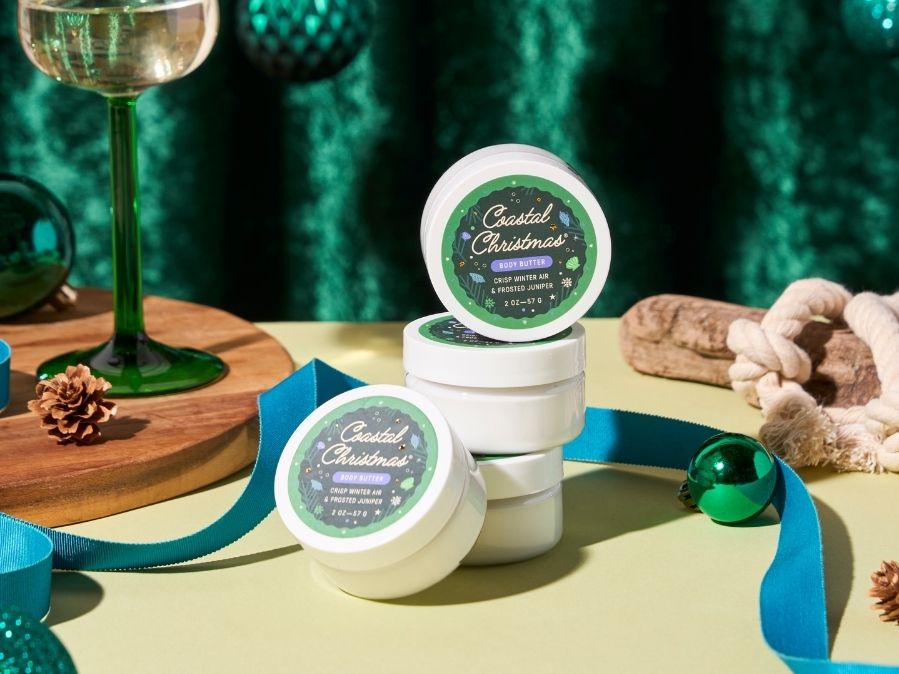 Small Coastal Christmas body butters stacked on a table with decorative elements
