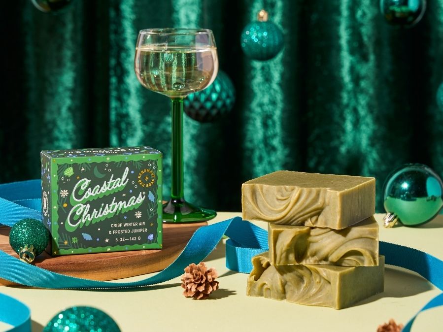 Coastal Christmas soap packaging with a bar of soap and a glass of wine on a decorative table.