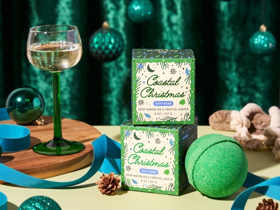 Coastal Christmas bath bombs with a glass of wine and decorative items on a table.