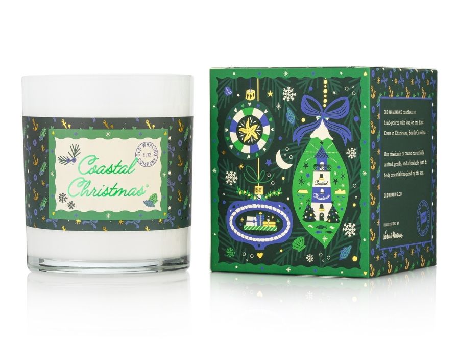 Candle with 'Coastal Christmas' label and decorative box on a white background