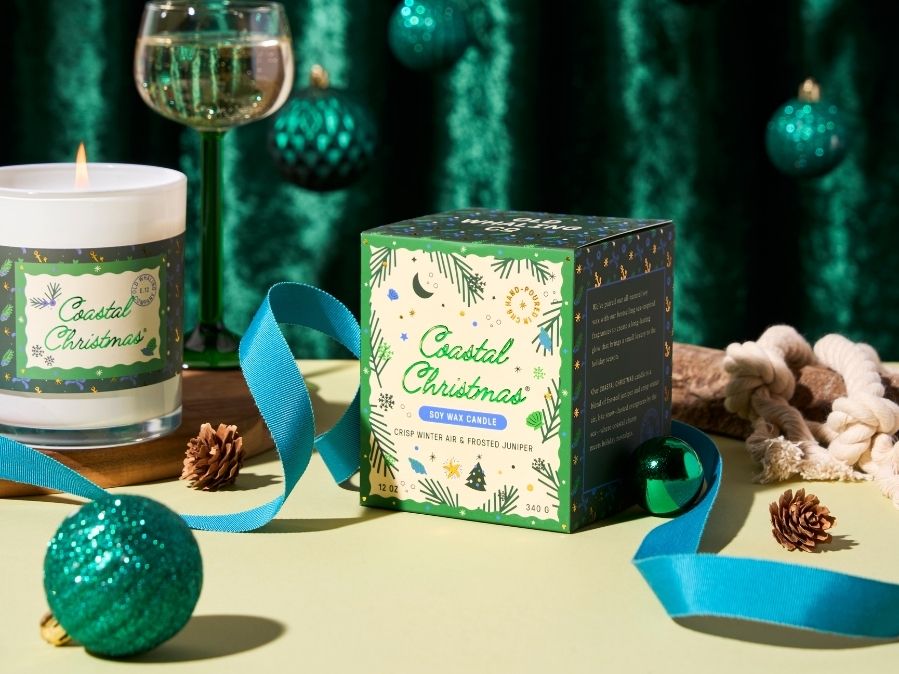 Coastal Christmas candle and packaging with decorative elements on a green background