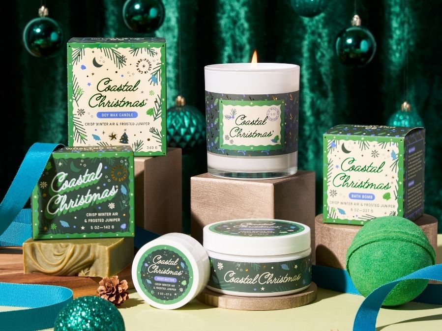 Coastal Christmas themed candles, body butter, bath bombs, and soaps with decorative green and blue elements.