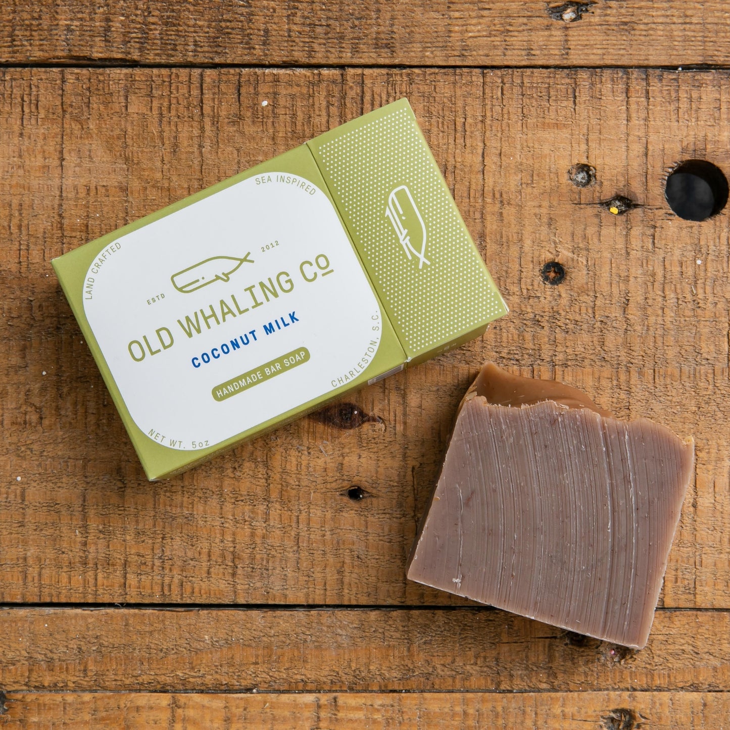 Coconut Milk Bar Soap and packaging laying on wood table