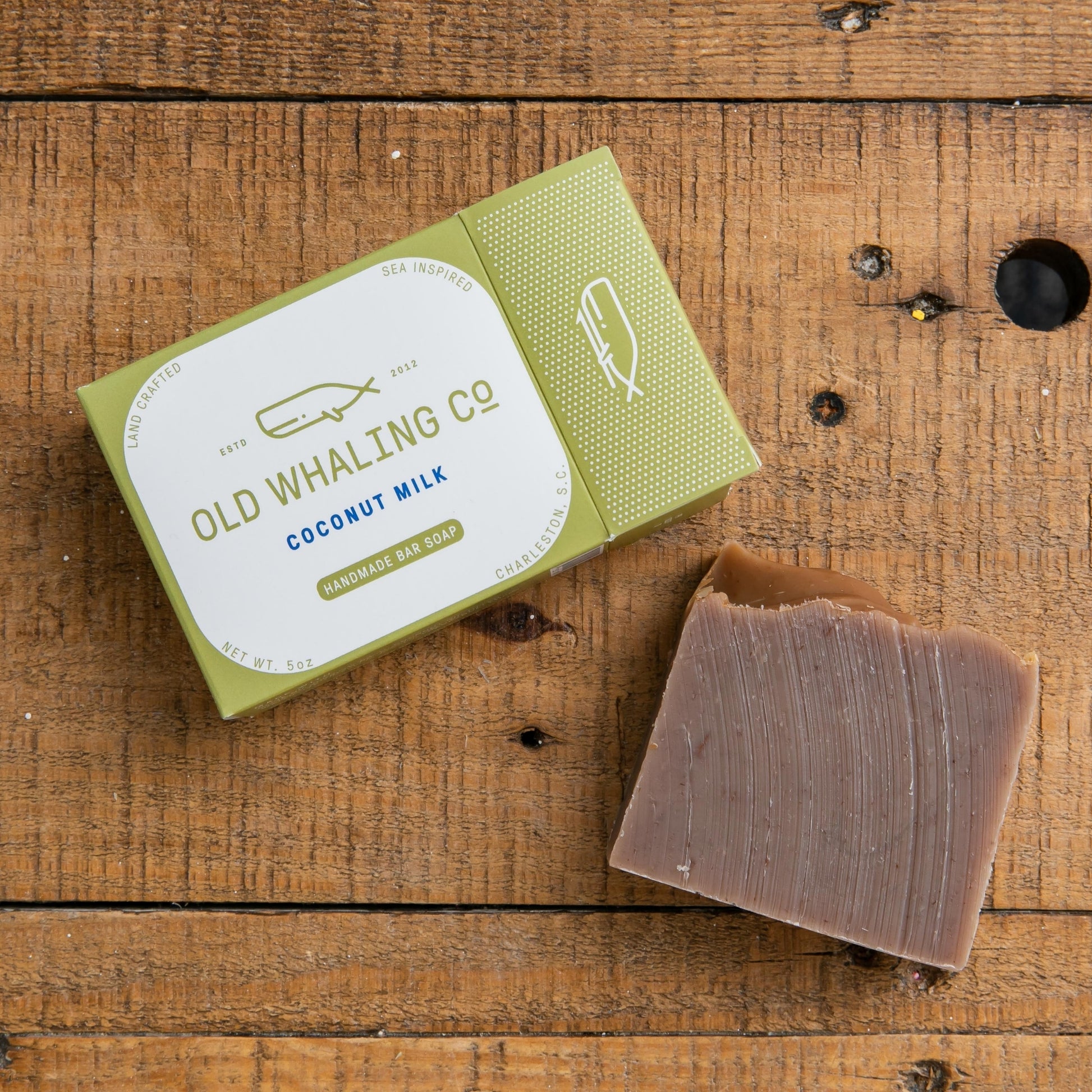 Coconut Milk Bar Soap and packaging laying on wood table