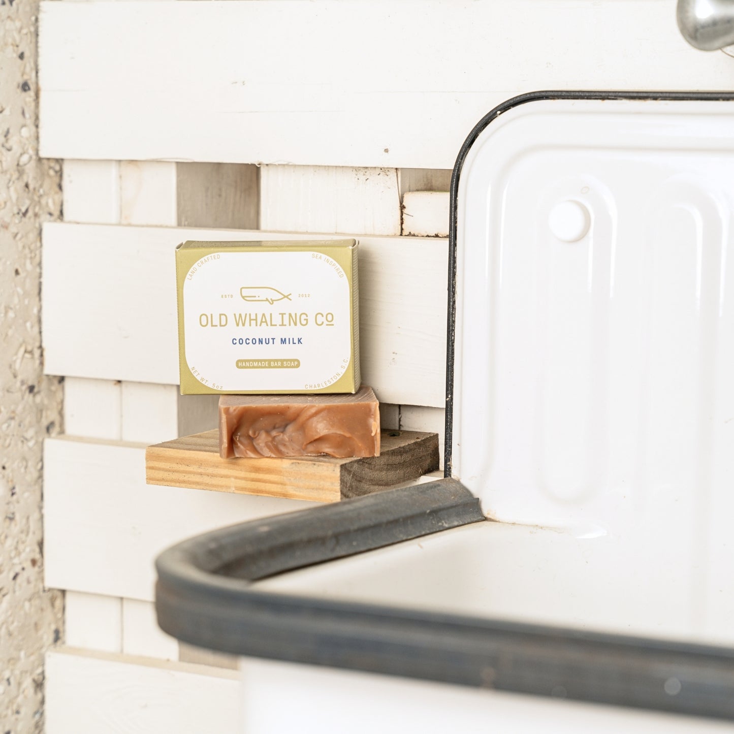 Coconut Milk Bar Soap and packaging on soap shelf beside vintage sink