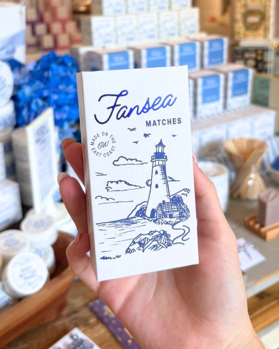 Hand holding a matchbook with 'Fansea Matches' design featuring a lighthouse.
