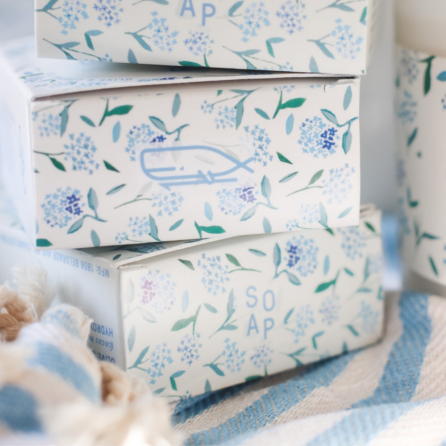 3 Floral Coast Bar Soap boxes stacked on blue and white striped fabric