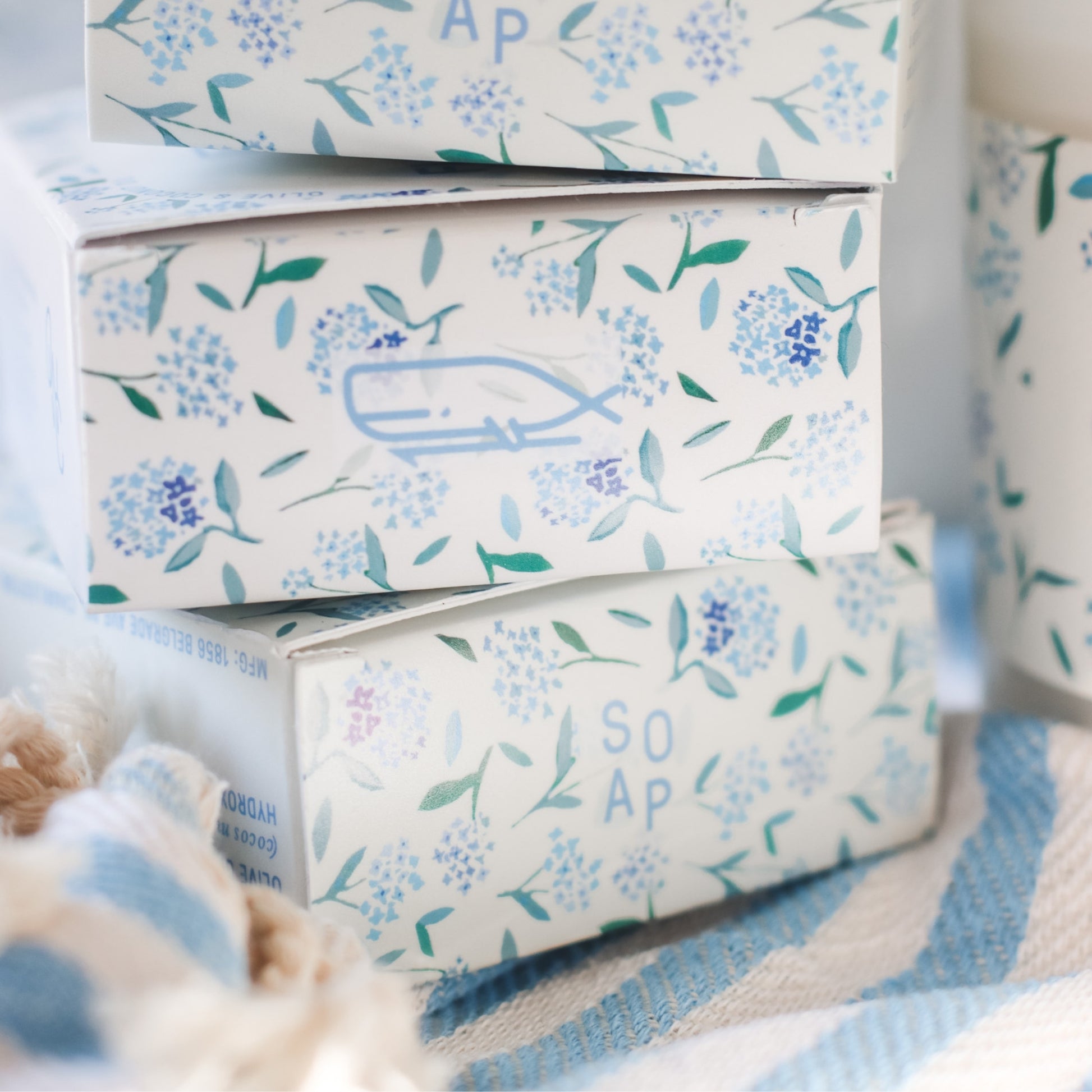 3 Floral Coast Bar Soap boxes stacked on blue and white striped fabric