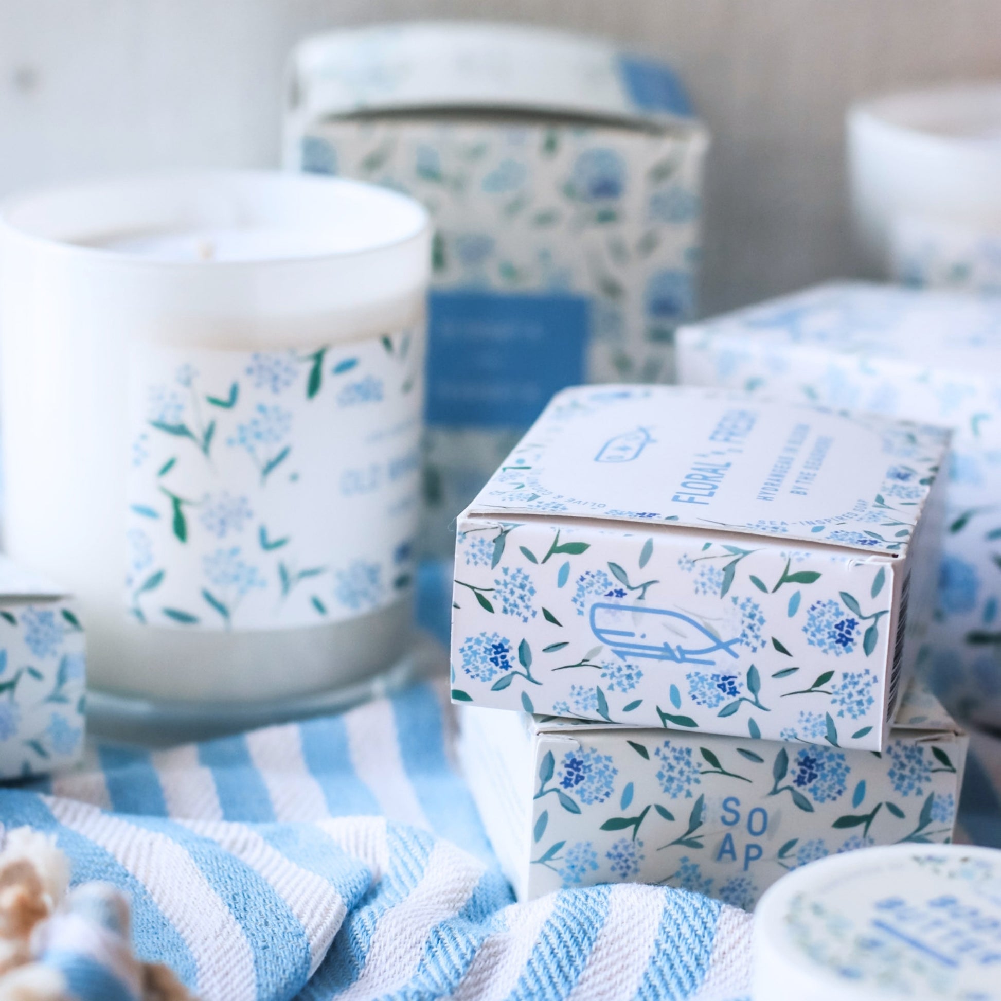 Floral Coast Bar Soap and Candles styled on blue and white striped fabric