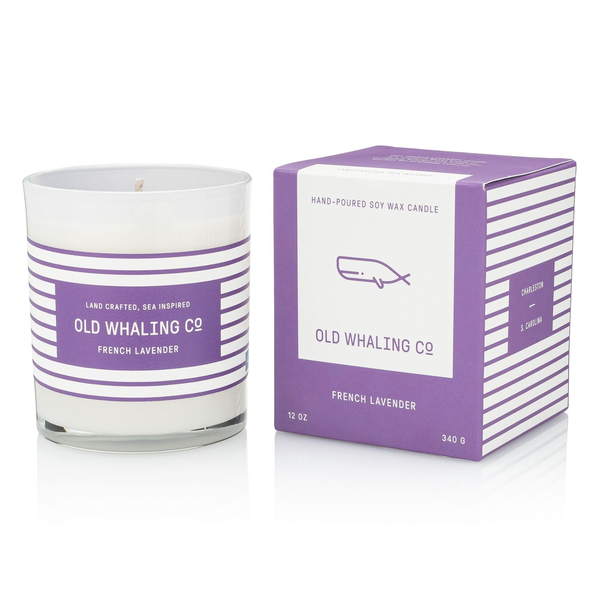 A white soy wax candle in a clear glass jar with purple and white horizontal stripes, shown next to its matching purple and white box. The label reads 'OLD WHALING C2' and 'FRENCH LAVENDER'.