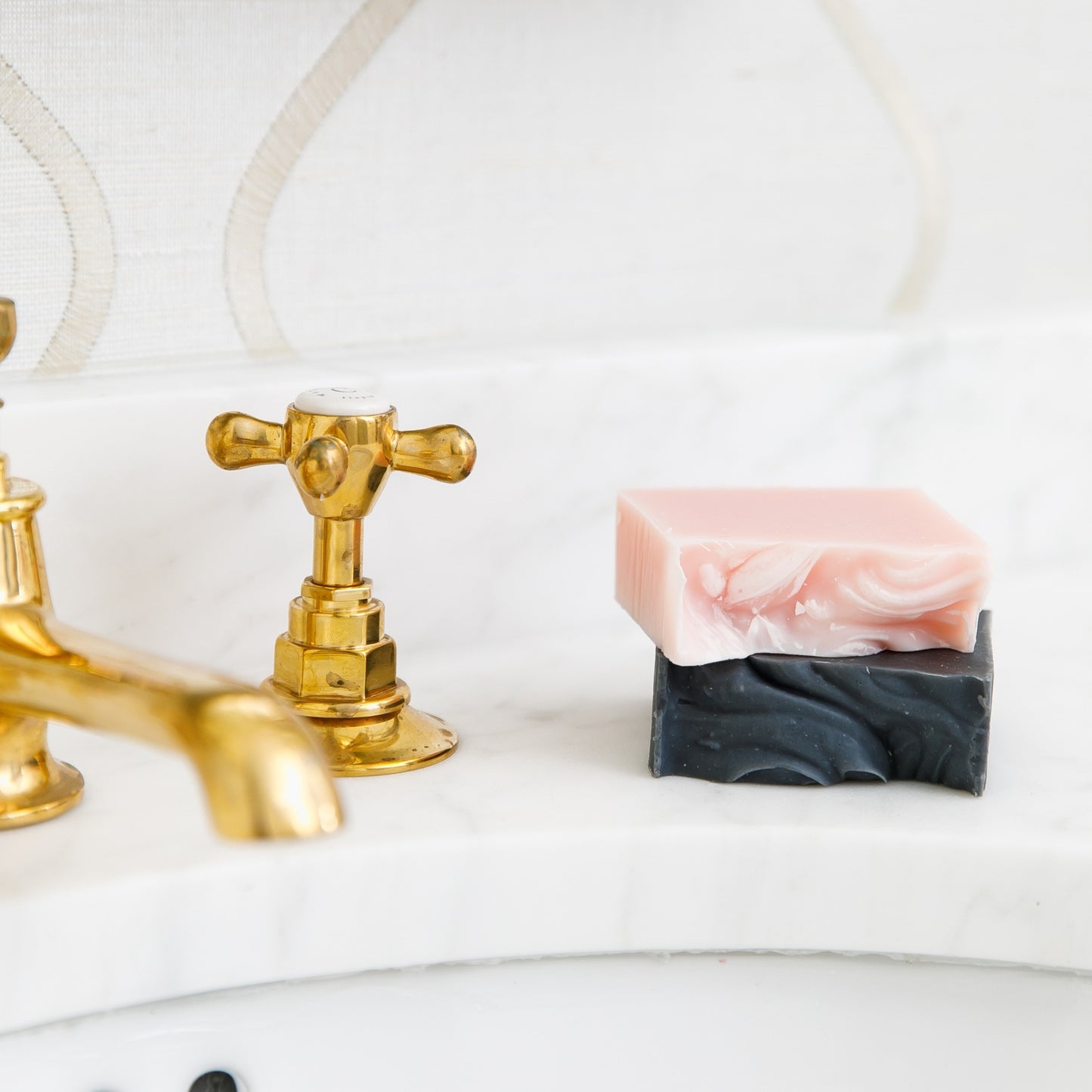 Unboxes Magnolia and Bergamot & Grapefruit Bar Soaps stacked on top of each other beside sink