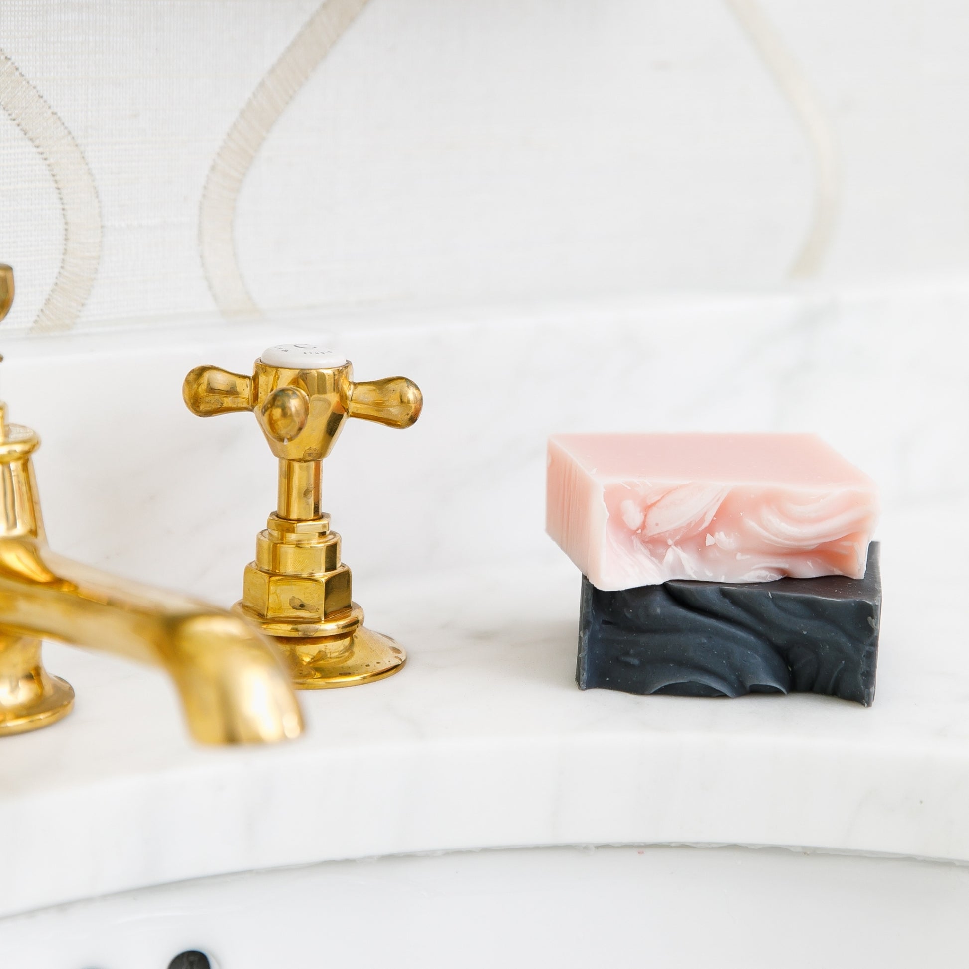 Unboxes Magnolia and Bergamot & Grapefruit Bar Soaps stacked on top of each other beside sink