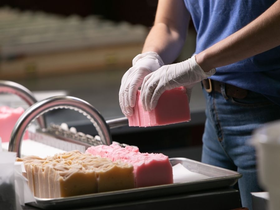 Cutting Magnolia soap handmade by Old Whaling Company in production warehouse in Charleston, SC