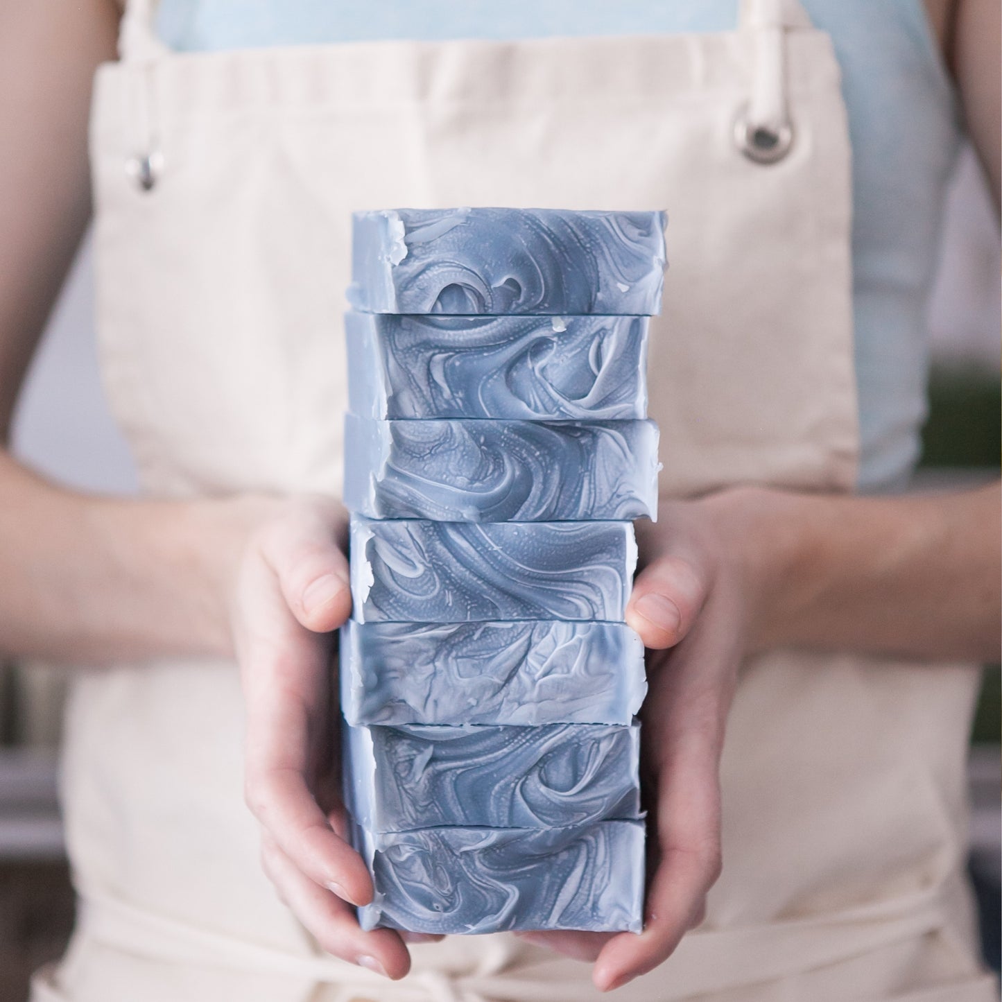 Hands holding stack of unboxes Oceanswept Bar Soap to reveal signature soap wave