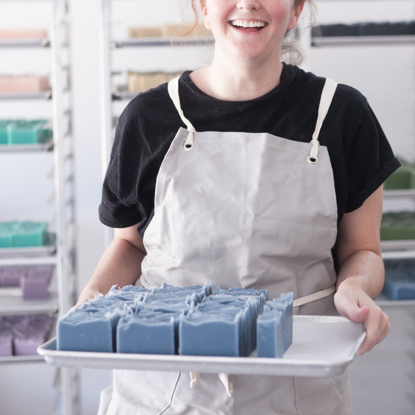 OWC Founder, April, holds tray of unboxed Oceanswept Bar Soaps while smiling