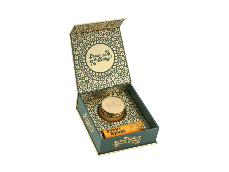 Open gift box with decorative lid and items inside on a white background