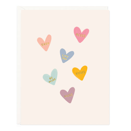 Colorful heart-shaped stickers with various sentiments on a beige background