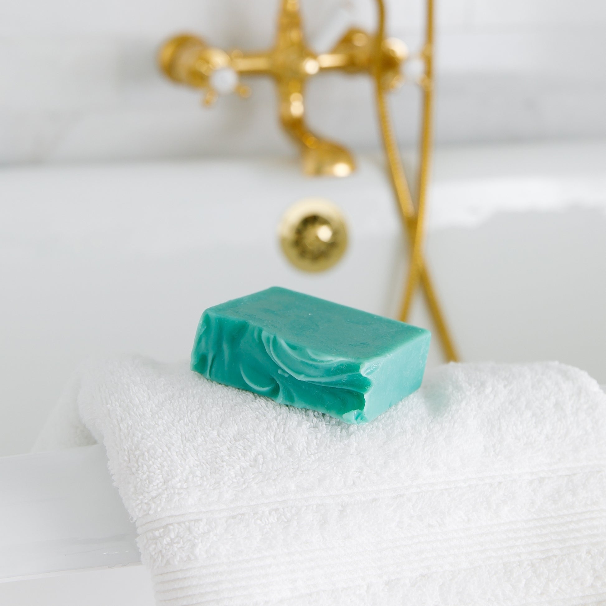 Unboxed Sea La Vie Bar Soap sits on white towel on ledge of bath tub