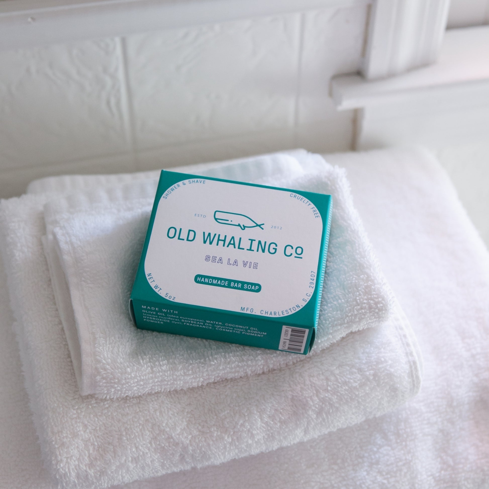 Sea La Vie Bar Soap box lays on stack of white towels