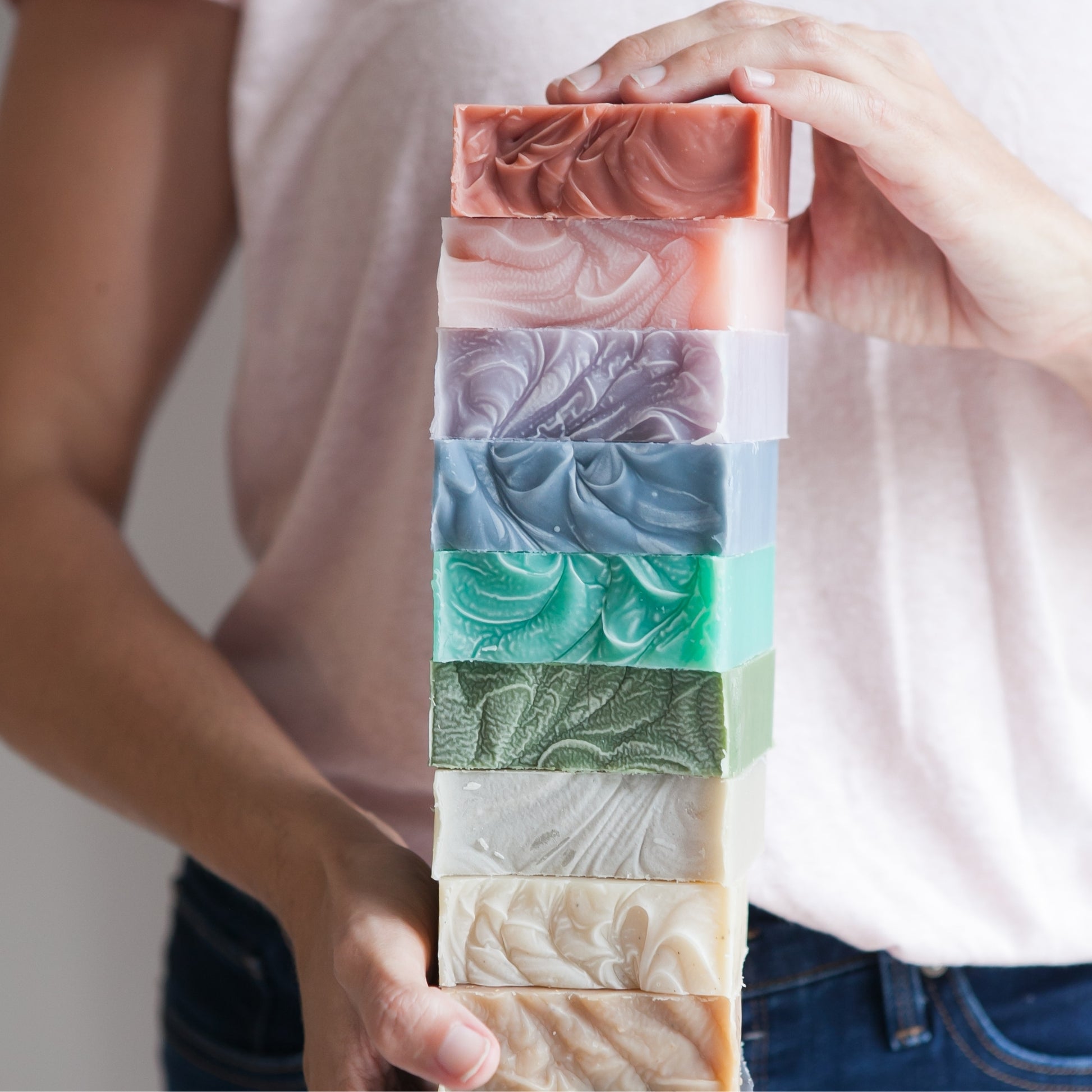 Hands holding assorted stack of unboxed Old Whaling Co Bar Soaps 