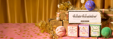 Bath bombs and gift boxes on a pink surface with a gold curtain background