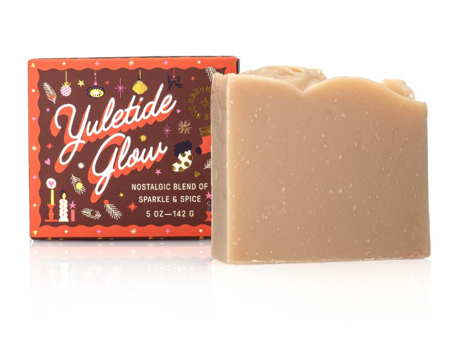 Bar of soap with a decorative Yuletide Glow packaging on a white background